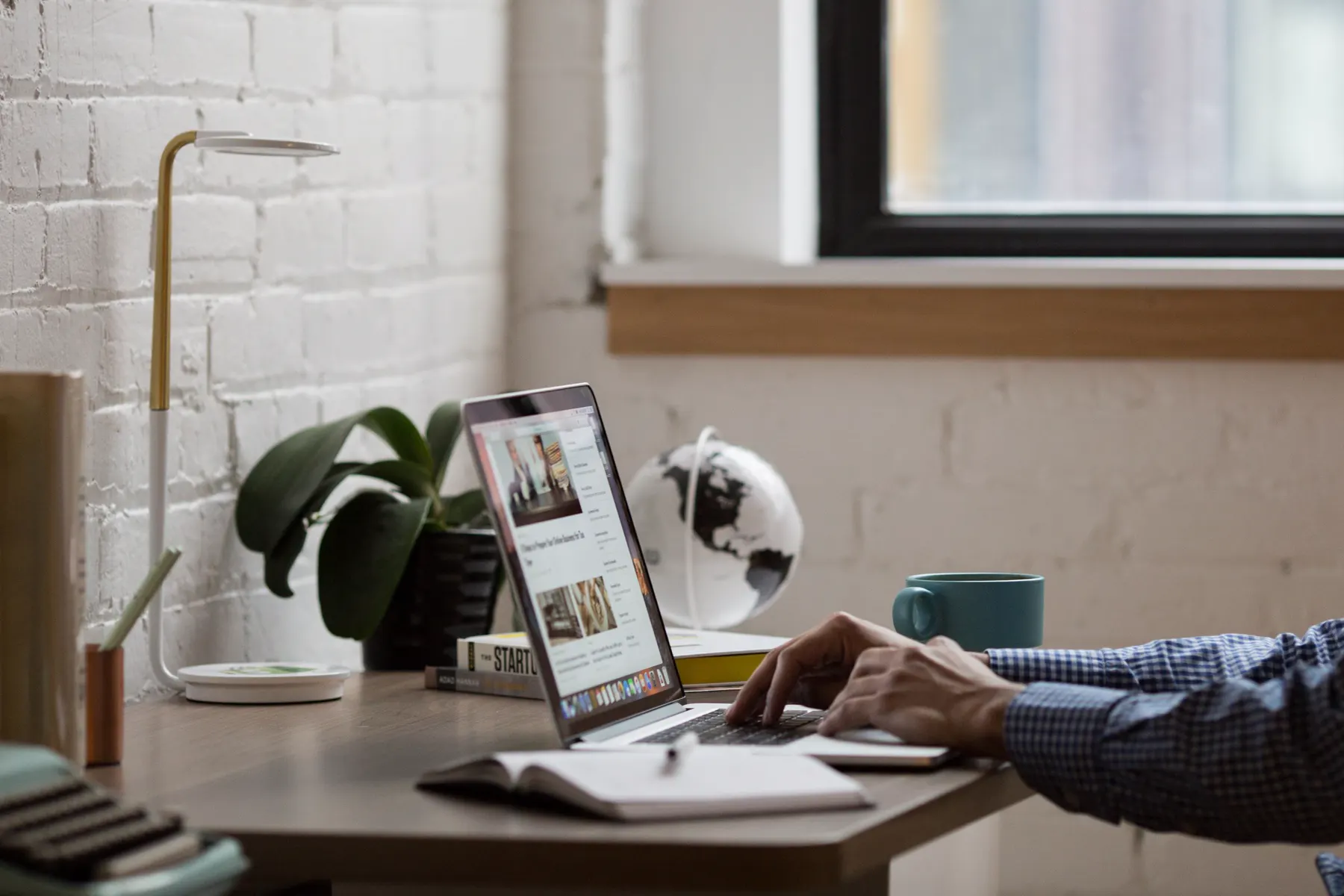 Person working with a laptop at a bright organized desk